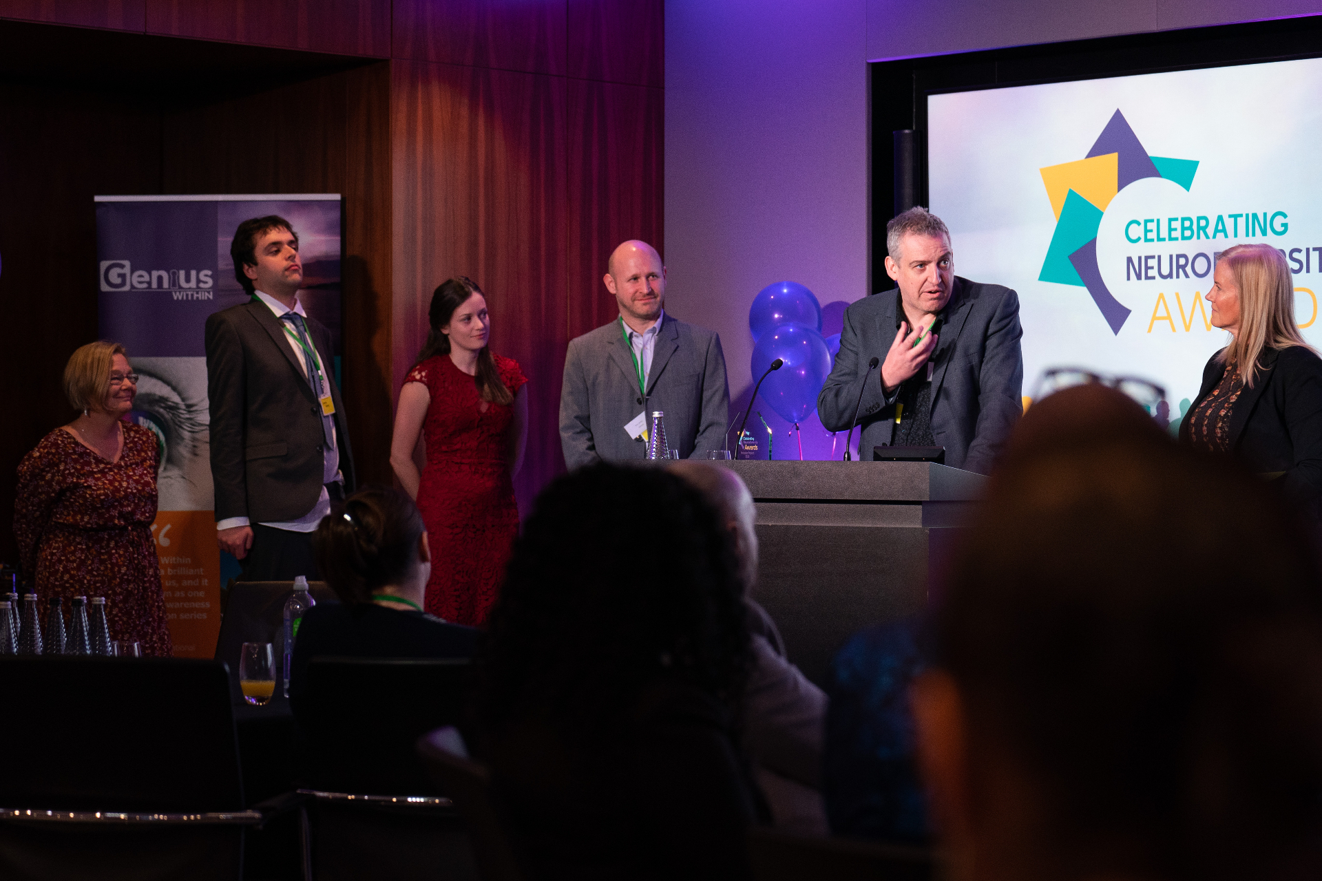 Wayne Kelly presenting on stage at the Celebrating Neurodiversity Awards