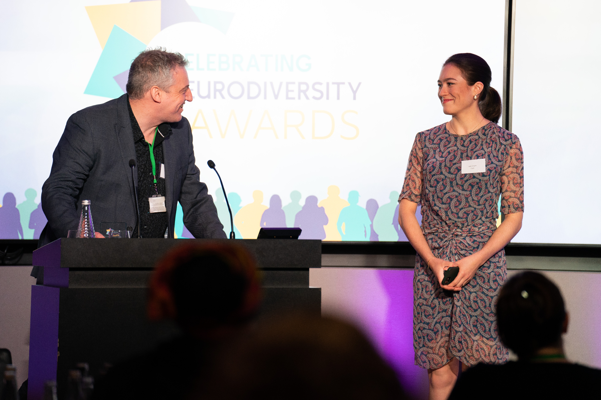 Wayne Kelly hosting a speaker on stage at the Celebrating Neurodiversity Awards